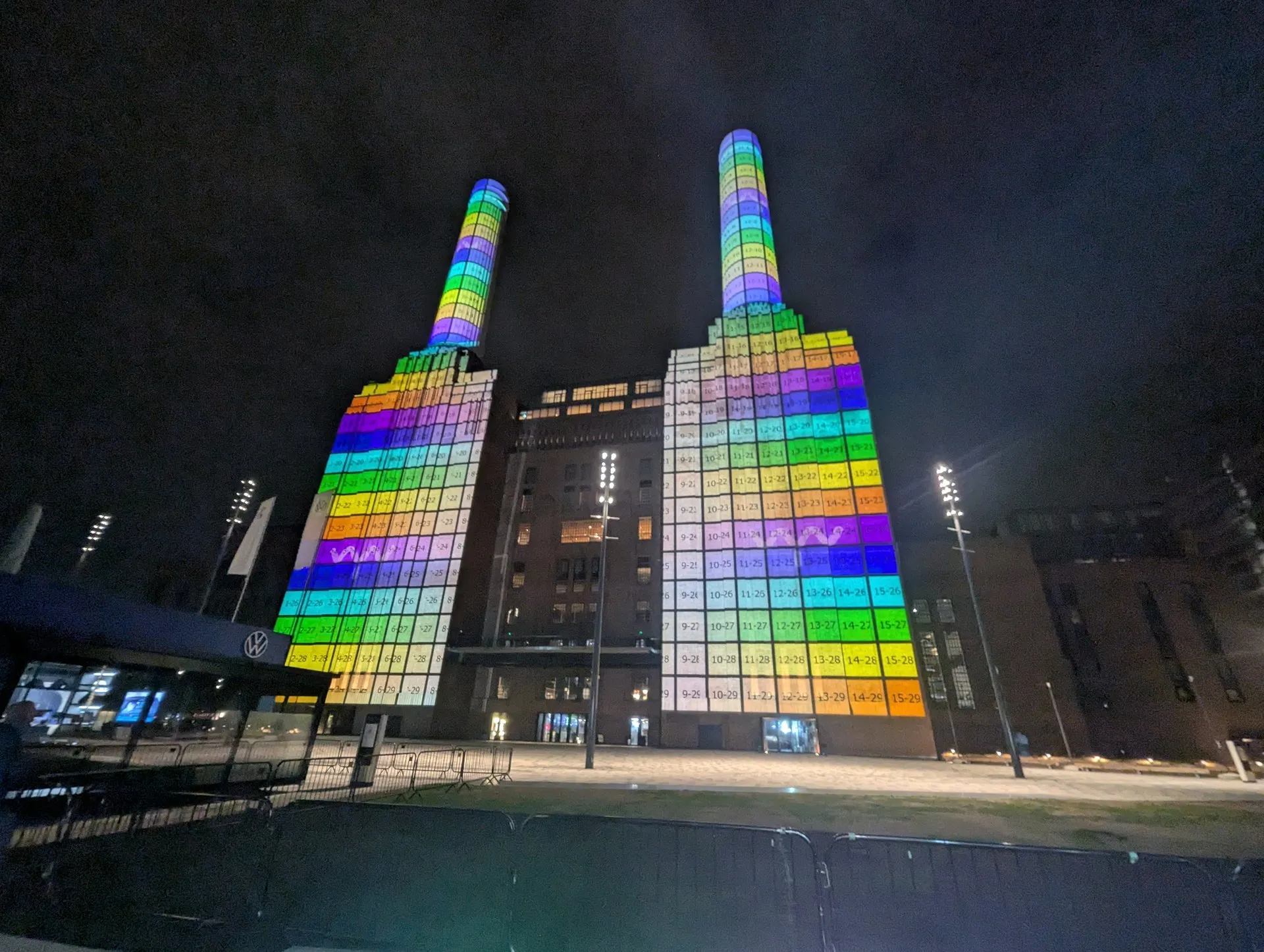 the same towers and chimneys covered in a grid of numbered coloured patches, one per projector zone, during an alignment night