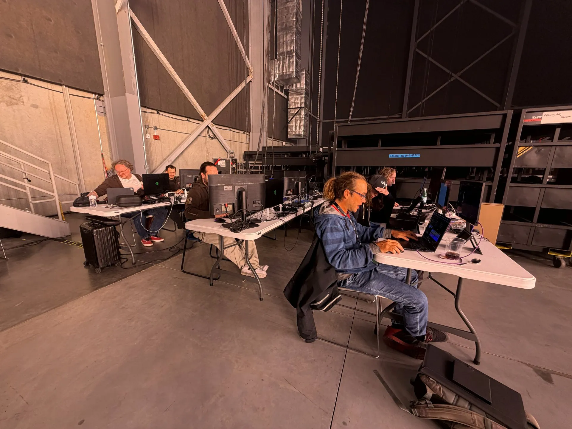 VYV developers and the Drop the Spoon team at folding tables, working on laptops and monitors